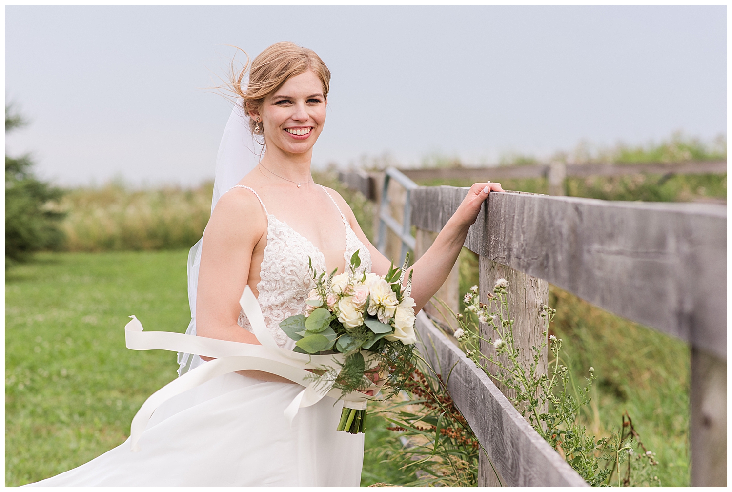 bride posing beside fence