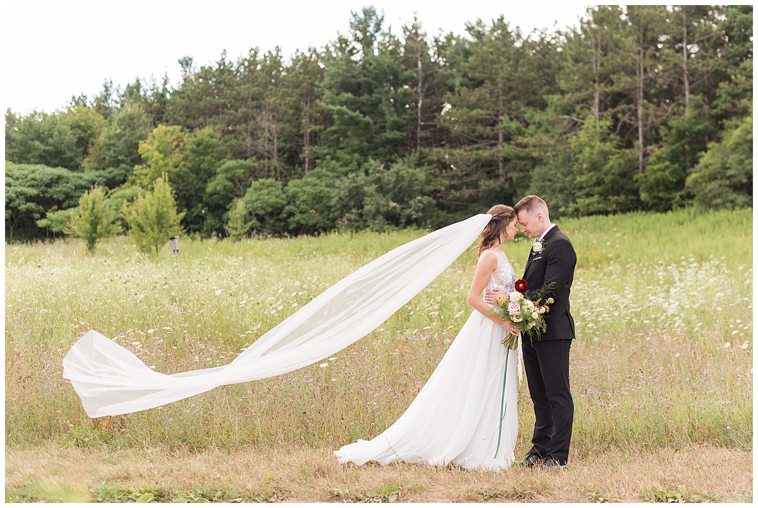 bride and groom with veil flying at huron natural area
