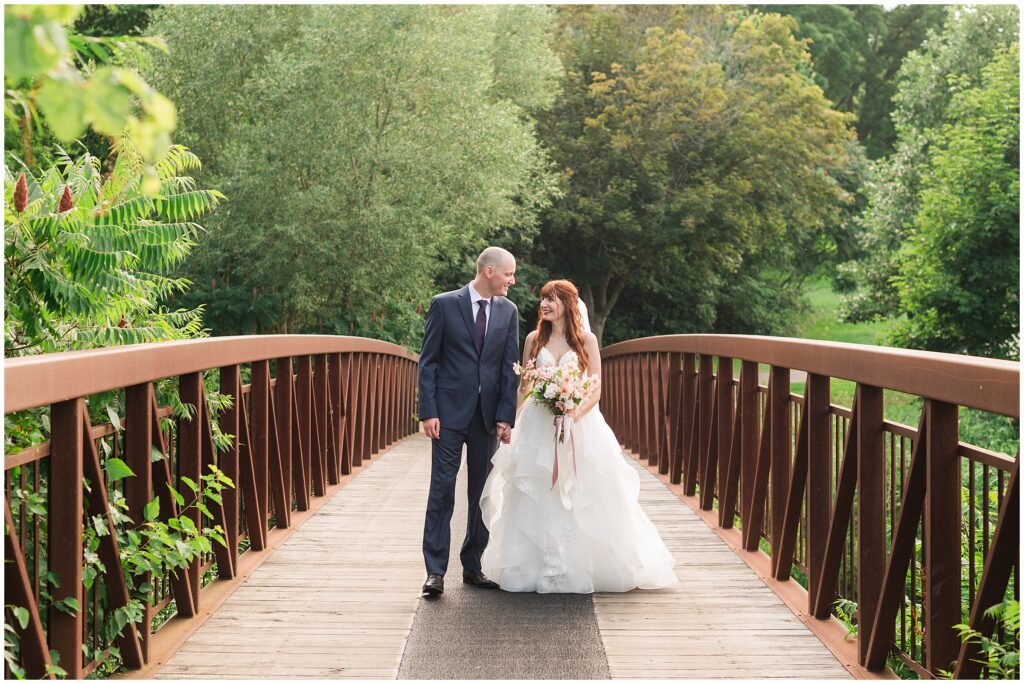 monica and jacob walking on a bridge at the islington golf club
